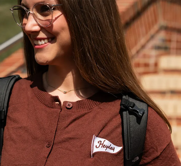 Girl wearing a sweater with a Heyday pennant patch