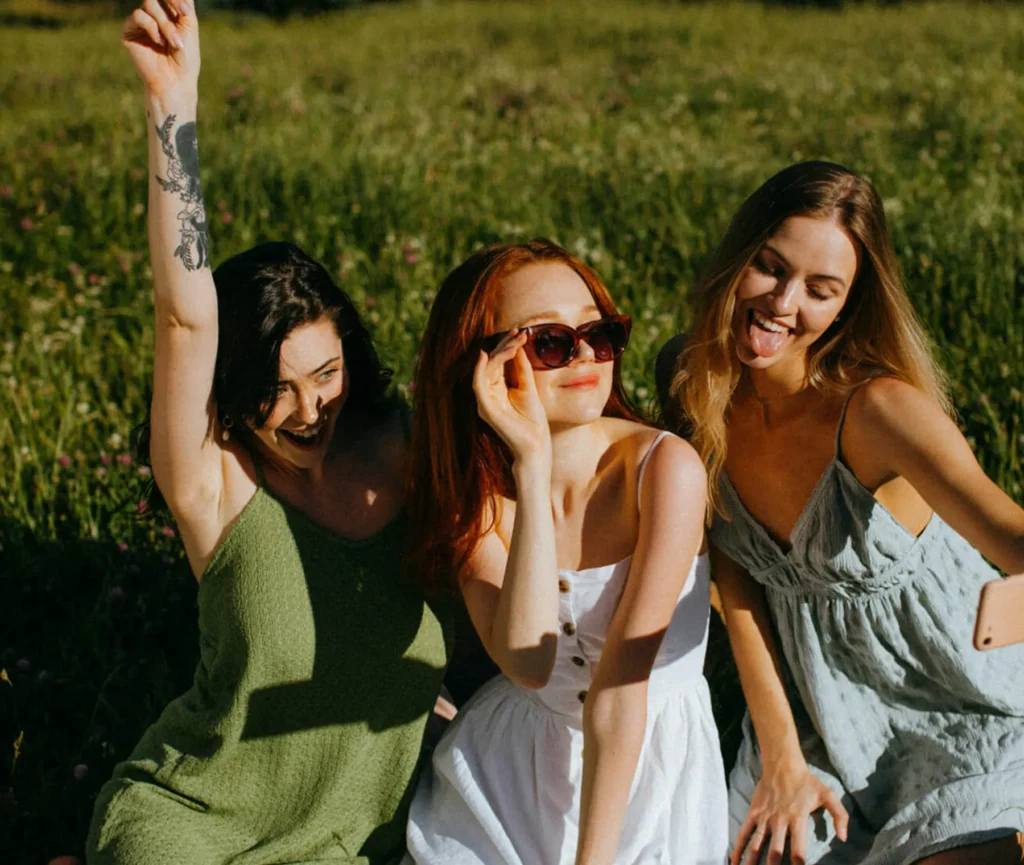 Three female friends at park on laughing and smiling having a picnic