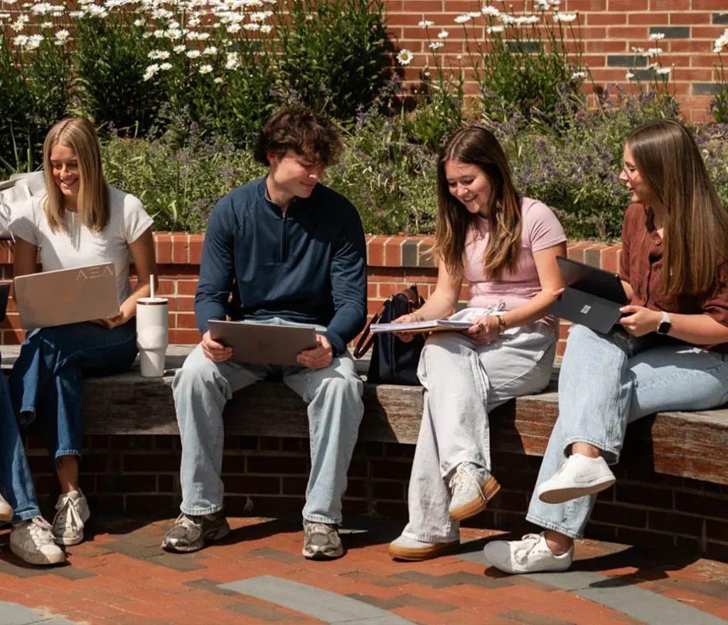 Group of friends studying and hanging out on campus outside