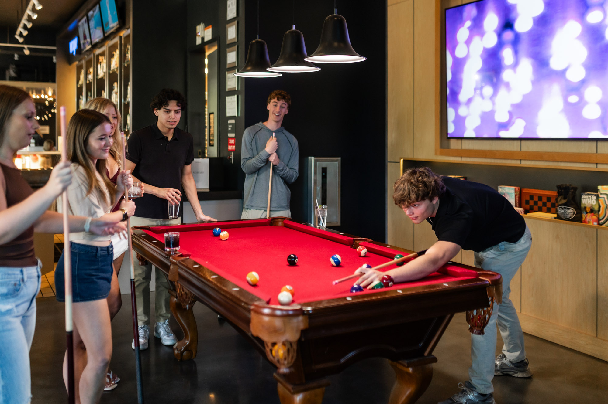 Friends playing billiards at local bar
