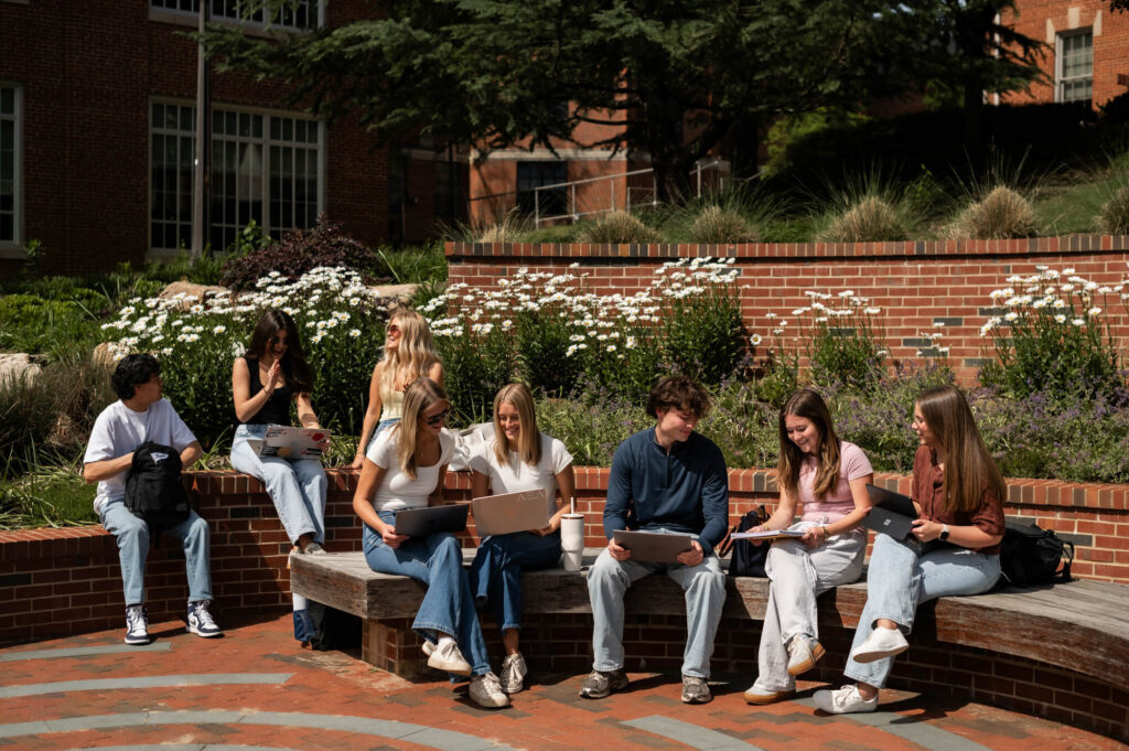 Group of friends studying and hanging out on campus outside