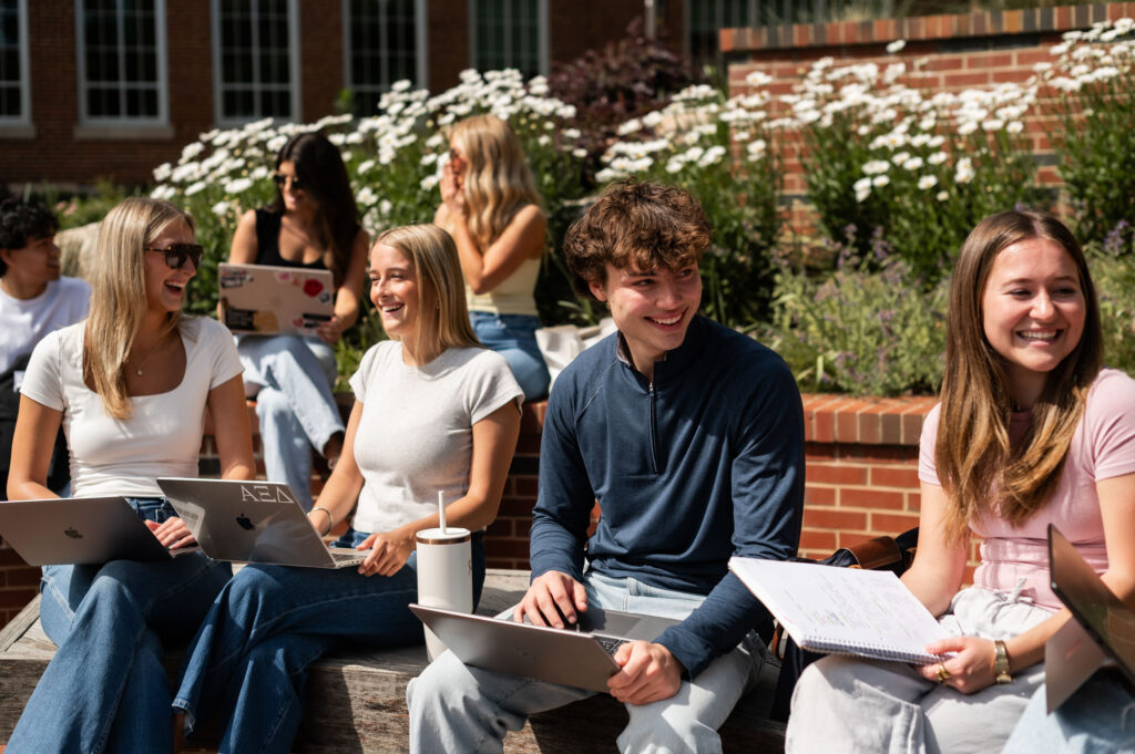 Group of friends studying and laughing outside
