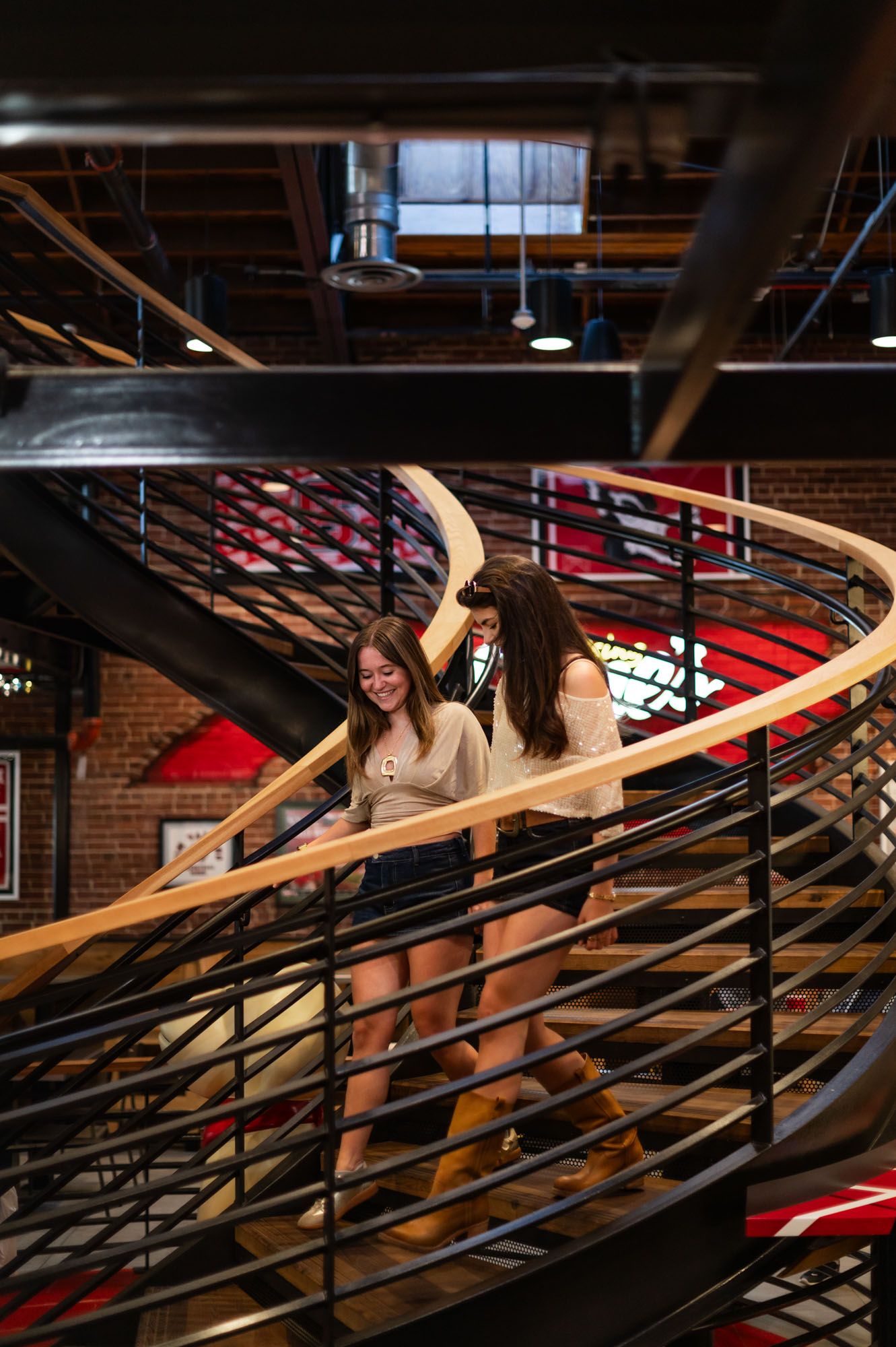 Two friends walking down spiral staircase