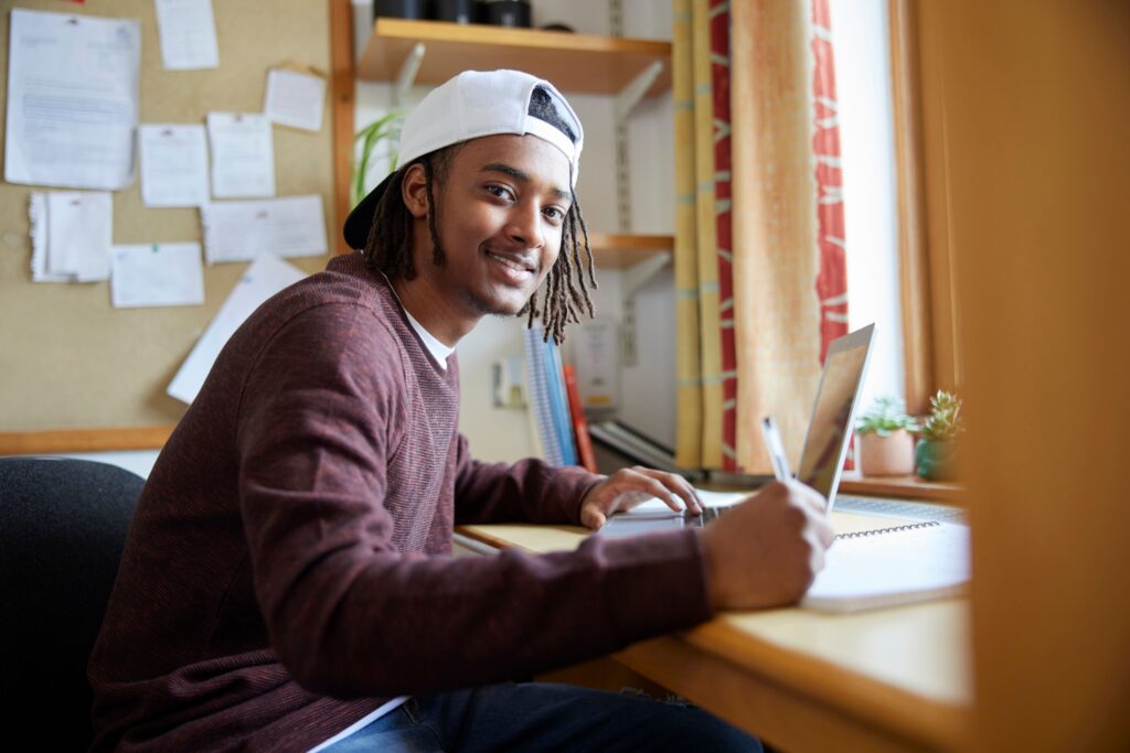 student studying at desk with laptop